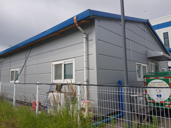 본건 2번 부동산의 외각 경계 철재 펜스따라 설치된 조립식판넬조 사무실 건물 1동 모습