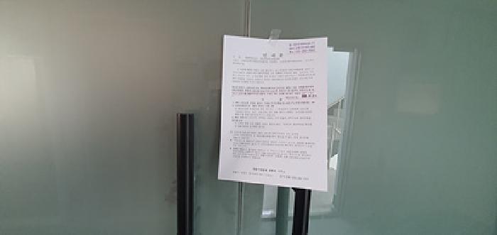 기호2 2층사무실 입구 출입문에 부동산경매 사건에 대한 안내문 게시(4/30일)