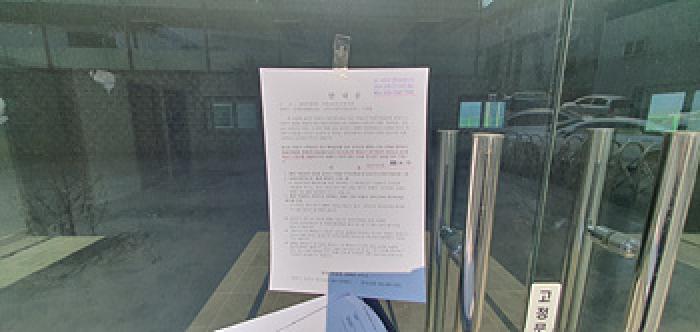 기호 8 제시 건물 부속 2층공장 사무실(다동) 1층출입문에 부동산경매 사건에 대한 안내문 부착 