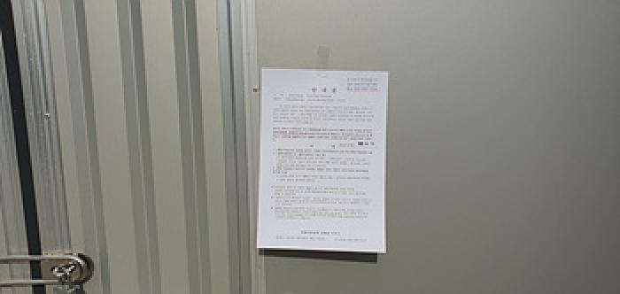 기호 8 제시 건물 단층 공장(가동) 출입문에 부동산경매 사건에 대한 안내문 부착 