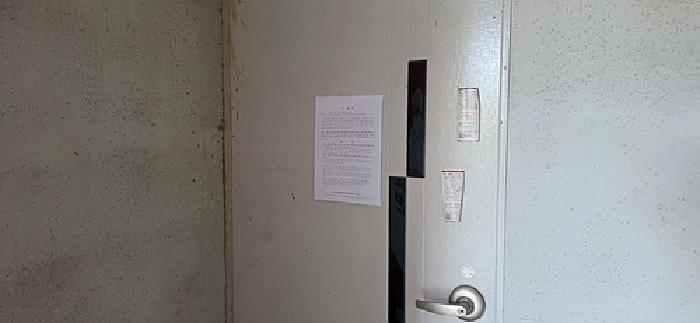 4번 부동산 건물 출입문 안내문 부착 모습