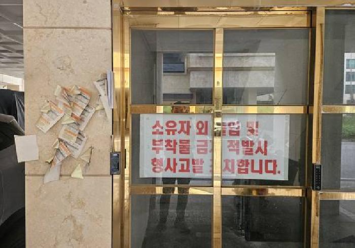 공동 출입구에 출입금지 안내문이 붙어 있음.