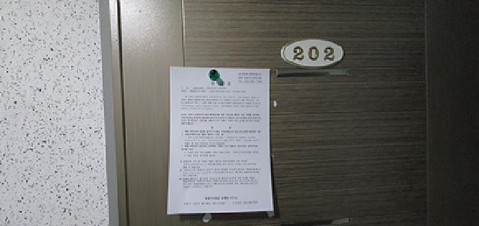 202호 출입문에 부동산경매 사건에 대한 안내문 게시(4/21일)