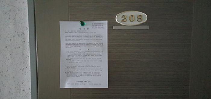 208호 출입문에 부동산경매 사건에 대한 안내문 게시(4/21일)