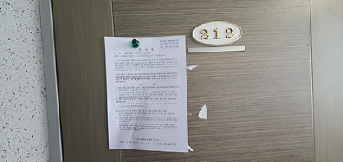 212호 출입문에 부동산경매 사건에 대한 안내문 게시(4/21일)