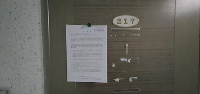217호 출입문에 부동산경매 사건에 대한 안내문 게시(4/21일)